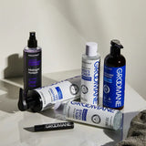 Grooming products including a spray bottle, gel, toner, and other items on a marble surface.